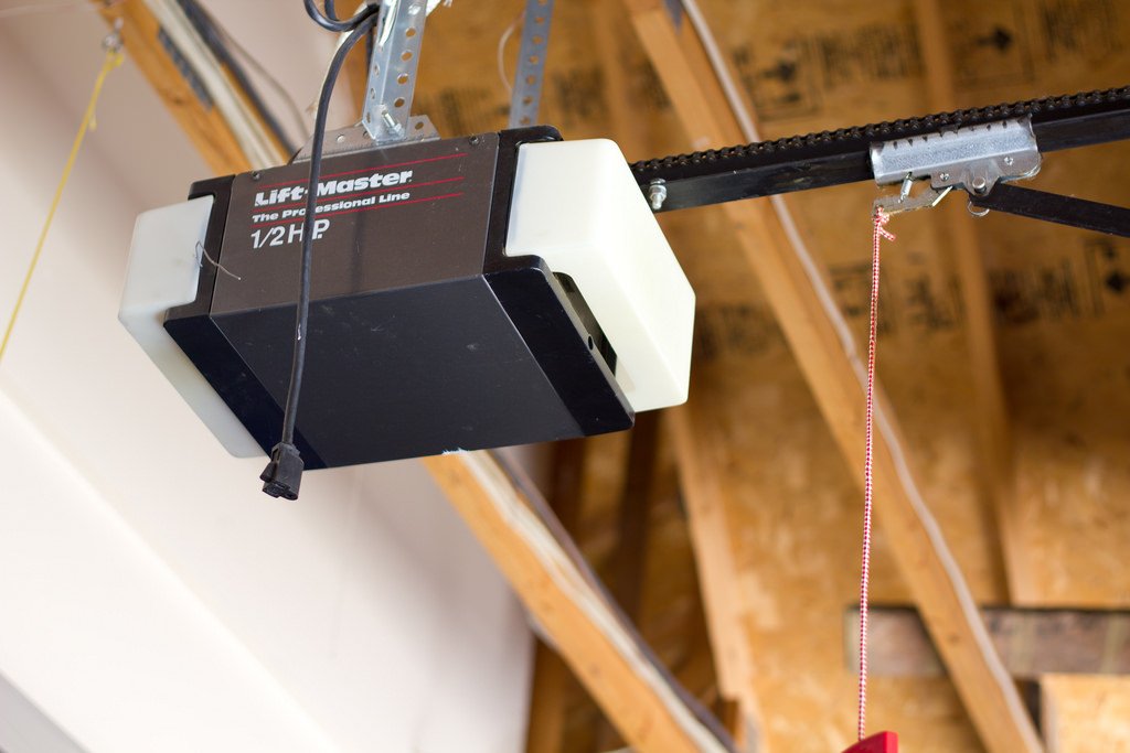 Close-up of tools being used to fix a garage door opener motor.