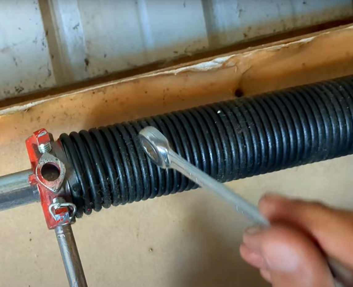 Technician repairing a broken garage door spring