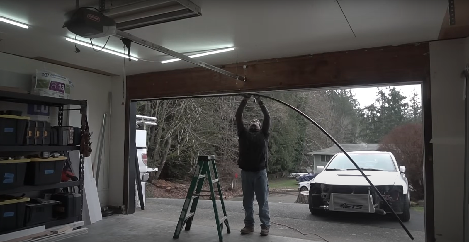 Garage door replacement process with tools and technician ensuring a perfect installation