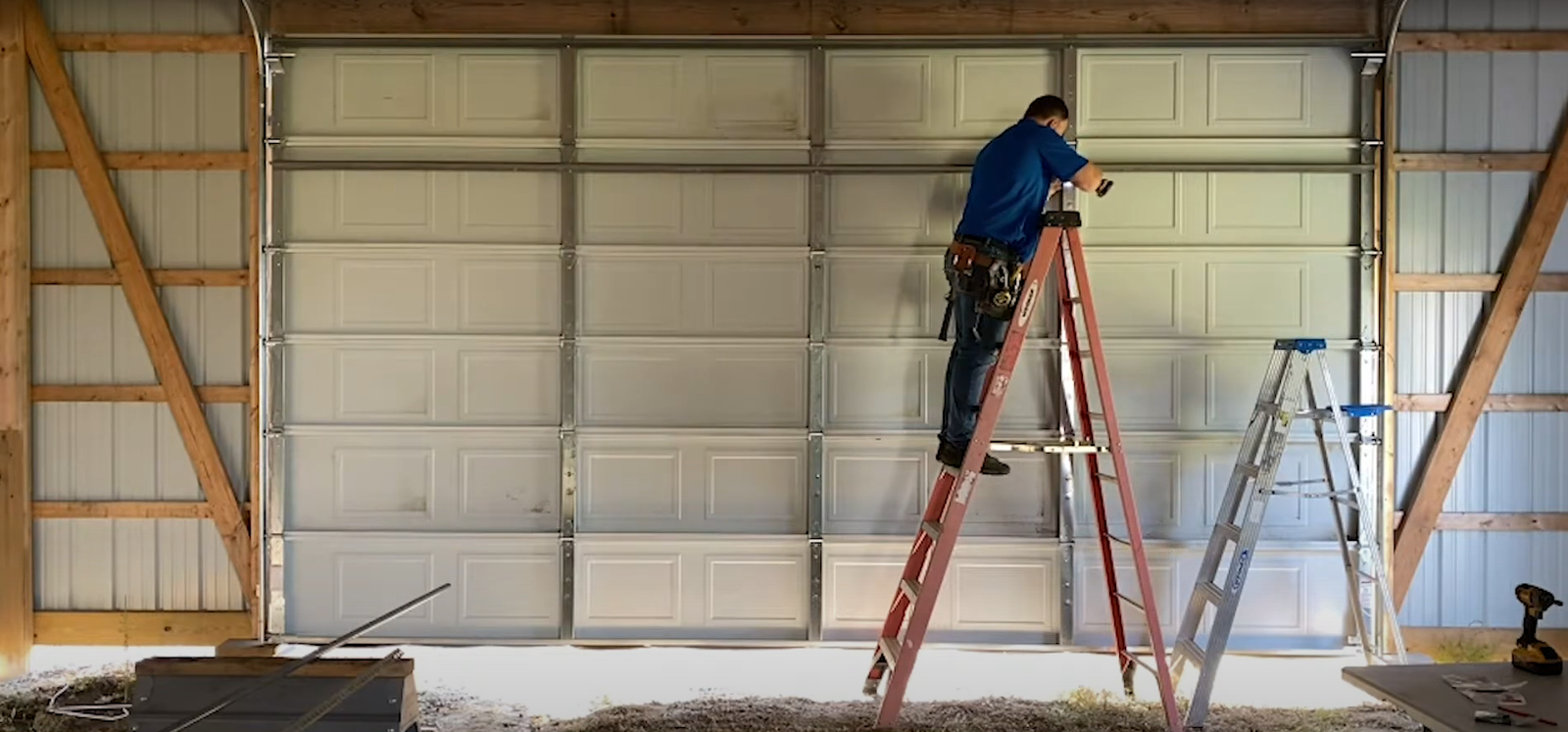 Residential garage door installation with modern white panel design and automatic opener.