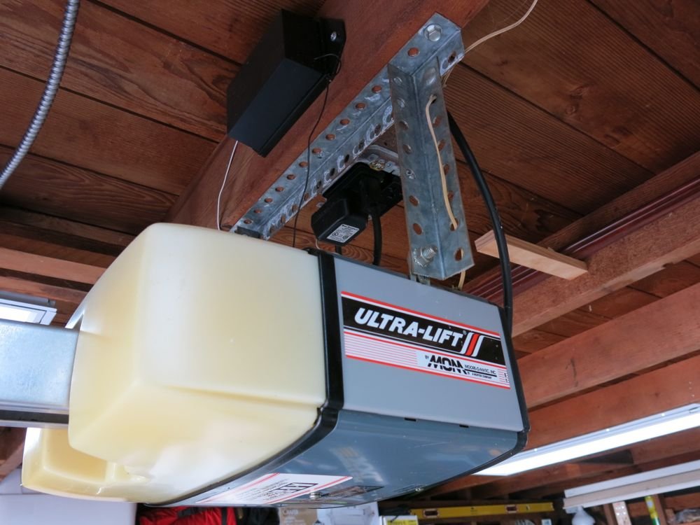 professional tech performing garage door installation in new home