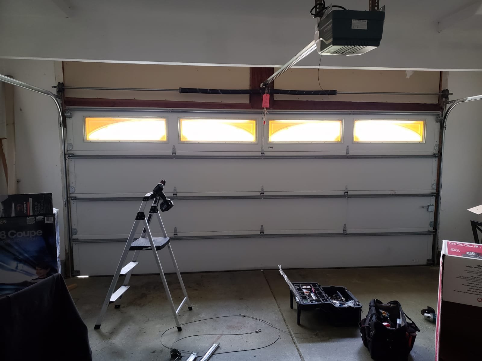 "A professional technician from Hilliard Garage Door Repair lubricating a garage door hinge during a maintenance session."