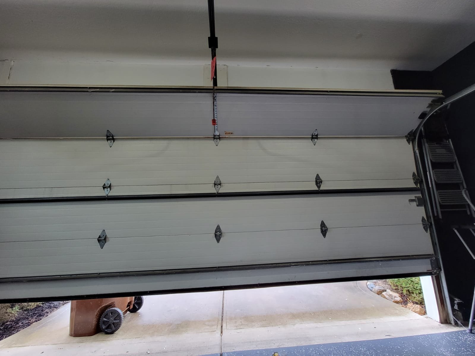 Garage door replacement process with tools and technician ensuring a perfect installation