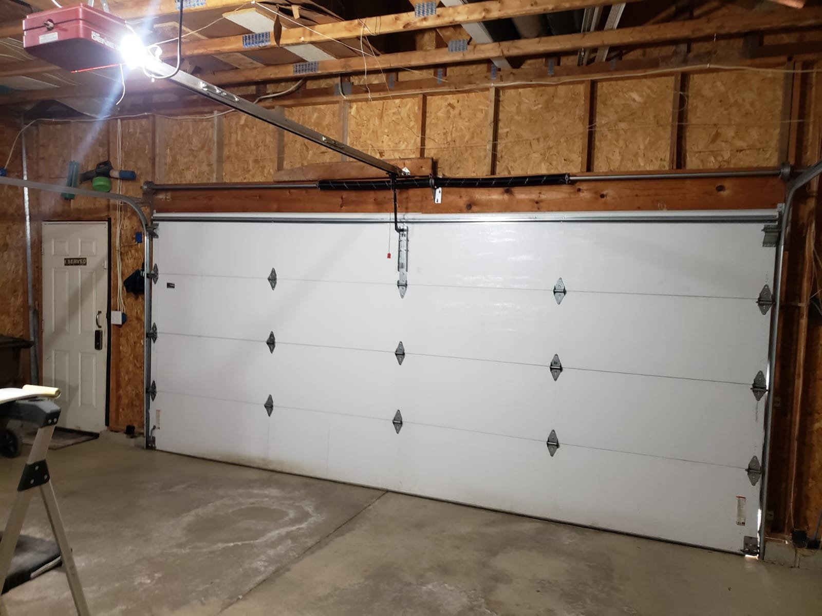 Professional repairing damaged garage door panels in Hilliard home