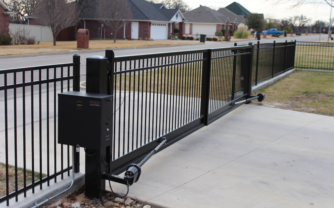 Automated driveway gate undergoing repair by a skilled worker.