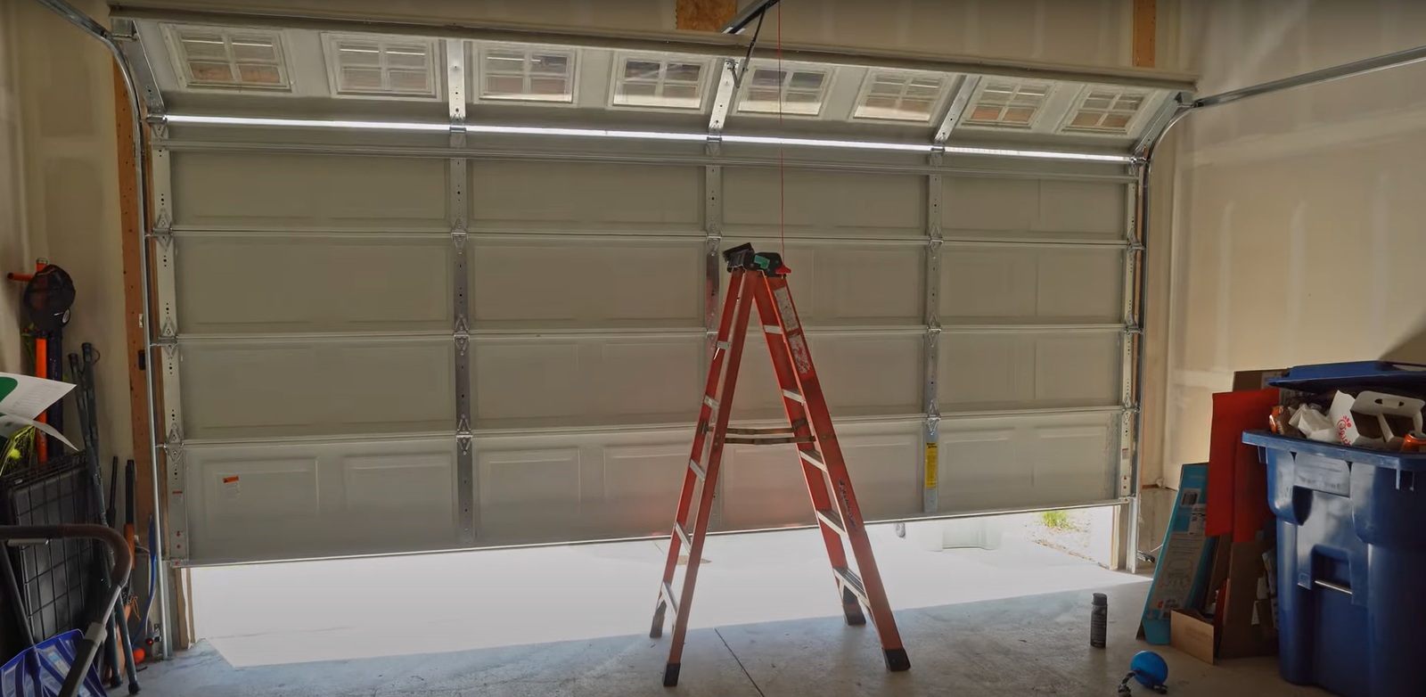 A professional technician from Hilliard Garage Door Repair inspecting a garage door track during a seasonal maintenance check.