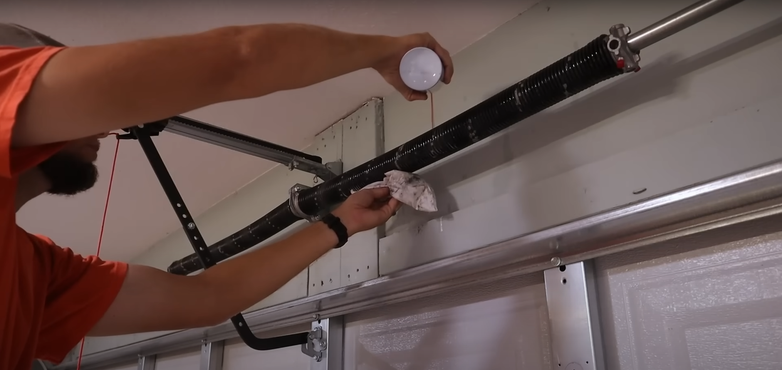 A professional technician from Hilliard Garage Door Repair repairing a garage door spring.