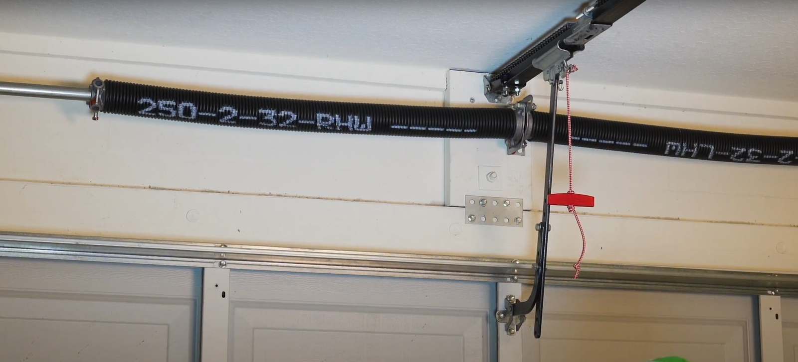 A technician from Hilliard Garage Door Repair inspecting and repairing a garage door spring system